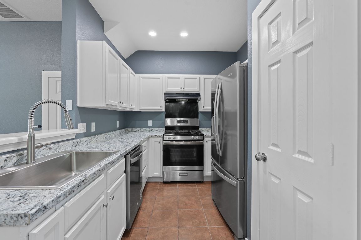 14517 Harris Ridge Boulevard, Unit B Pflugerville, TX 78660 - Photo 10 of 26 a kitchen with granite countertop a sink stove and refrigerator