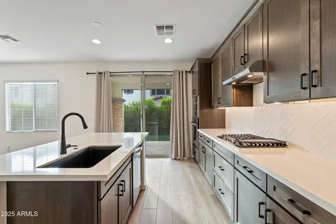 a kitchen with stainless steel appliances granite countertop a sink a stove and a refrigerator
