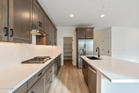 a kitchen with stainless steel appliances granite countertop a sink stove and refrigerator