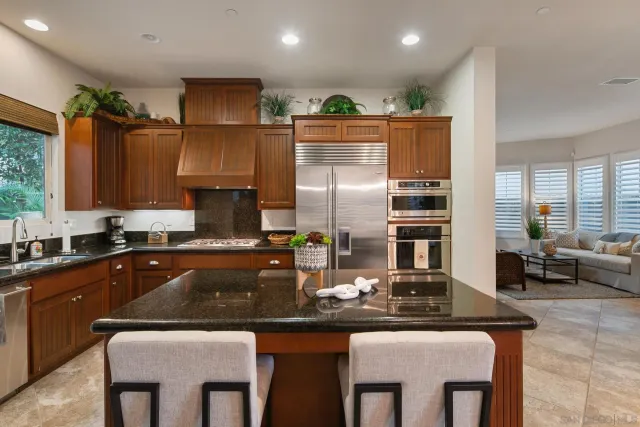 a kitchen with stainless steel appliances granite countertop a sink and a refrigerator