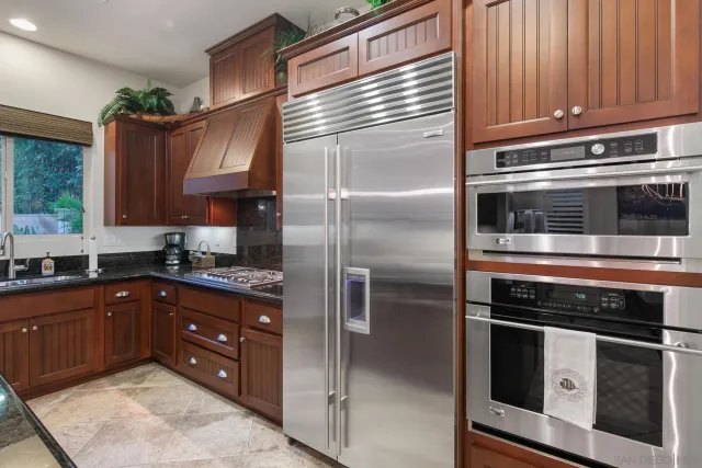 a kitchen with stainless steel appliances granite countertop a stove and a refrigerator