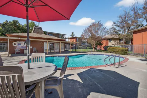a view of a house with swimming pool and sitting area