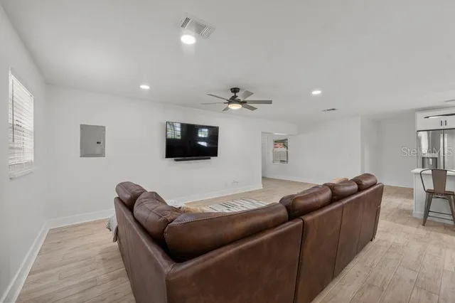 a living room with furniture and a ceiling fan