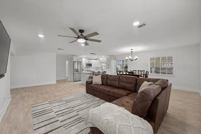 a living room with furniture a flat screen tv and a wooden floor