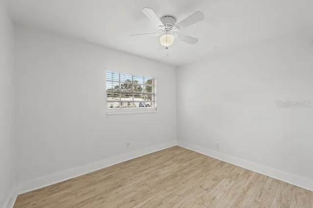 a view of a room with wooden floor and a ceiling fan