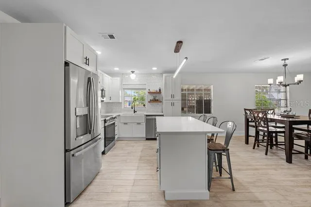 a kitchen with white cabinets stainless steel appliances and sink