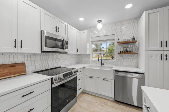 a kitchen with kitchen island a dining table chairs stainless steel appliances and cabinets
