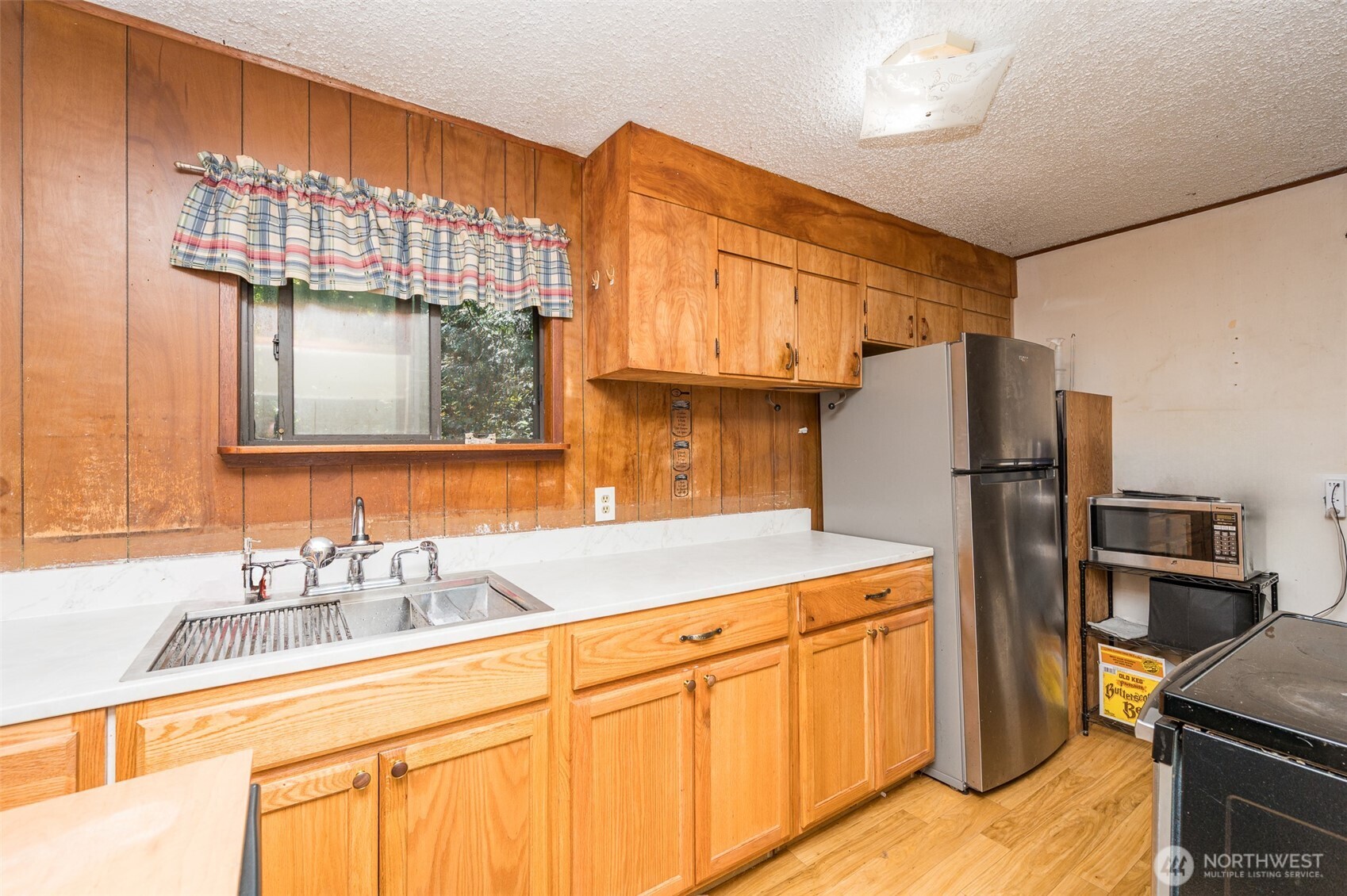1671 Northeast Mission Creek Road Belfair, WA 98528 - Photo 9 of 31 a kitchen with a sink refrigerator and microwave