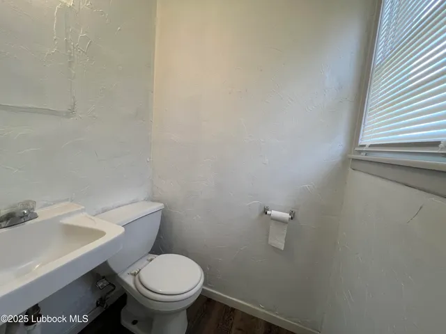a white toilet sitting next to a white sink and a small window