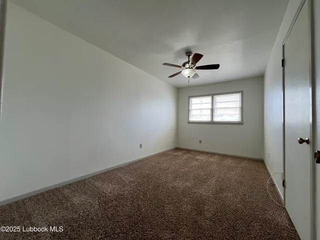 a view of a room with window and ceiling fan