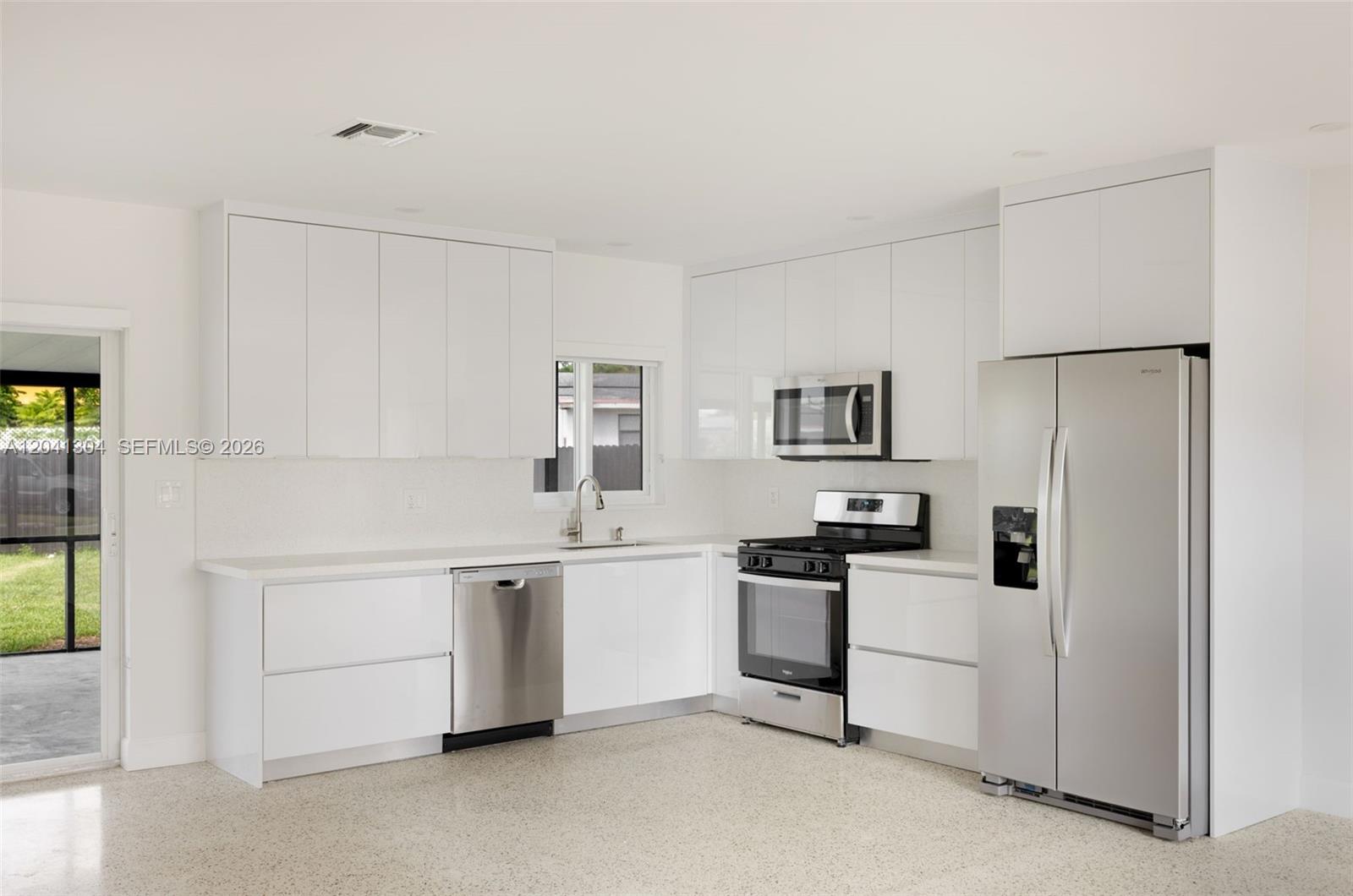 10340 Southwest 157th Street Miami, FL 33157 - Photo 6 of 24 Kitchen – Contemporary finishes and clean lines define this well-appointed kitchen. Generous cabinetry and a practical layout make meal preparation and hosting effortless.