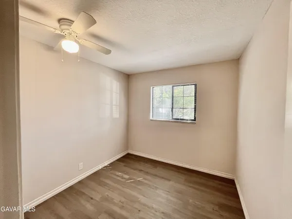 an empty room with a window and a fan