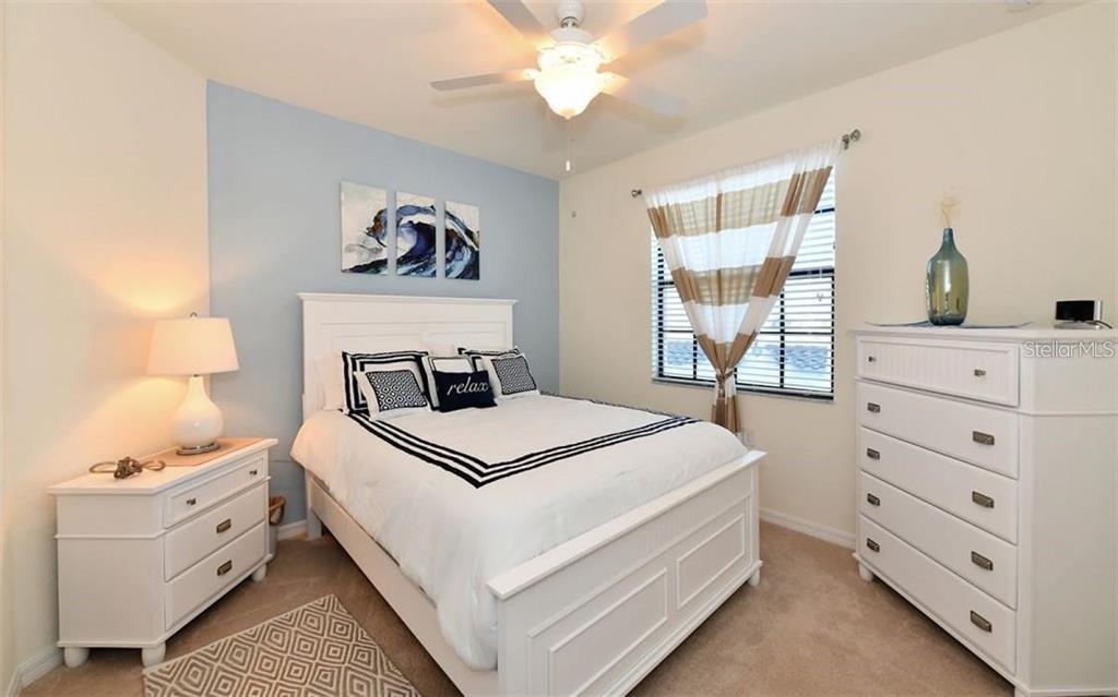 16904 Vardon Terrace, Unit 201 Lakewood Ranch, FL 34211 - Photo 19 of 35 a bedroom with a bed and a window