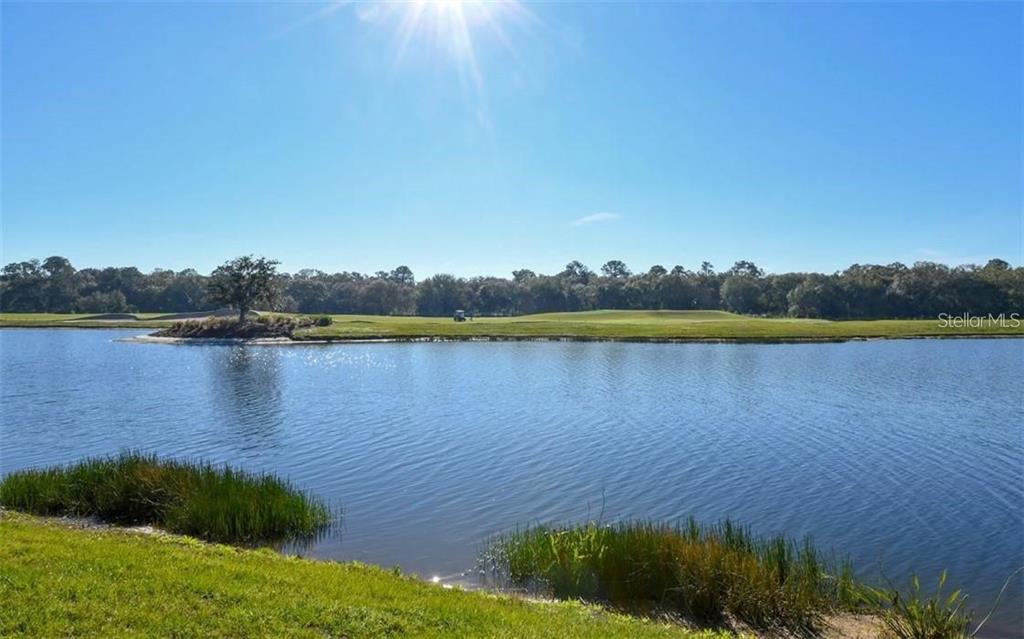 16904 Vardon Terrace, Unit 201 Lakewood Ranch, FL 34211 - Photo 24 of 35 a view of a lake with houses in the back