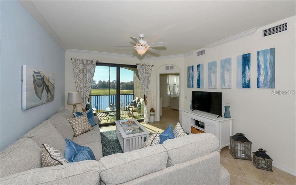 16904 Vardon Terrace, Unit 201 Lakewood Ranch, FL 34211 - Photo 5 of 35 a living room with furniture and a flat screen tv