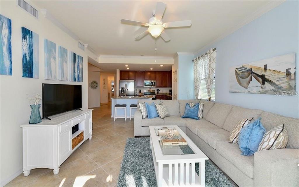 16904 Vardon Terrace, Unit 201 Lakewood Ranch, FL 34211 - Photo 7 of 35 a living room with furniture and a flat screen tv