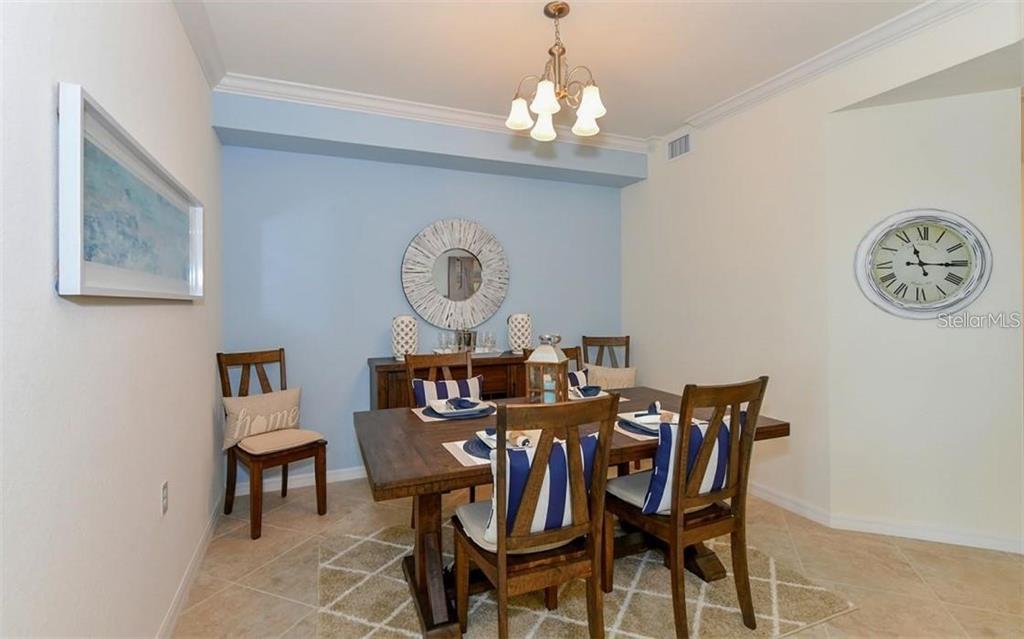 16904 Vardon Terrace, Unit 201 Lakewood Ranch, FL 34211 - Photo 9 of 35 a view of a dining room and a table and chairs