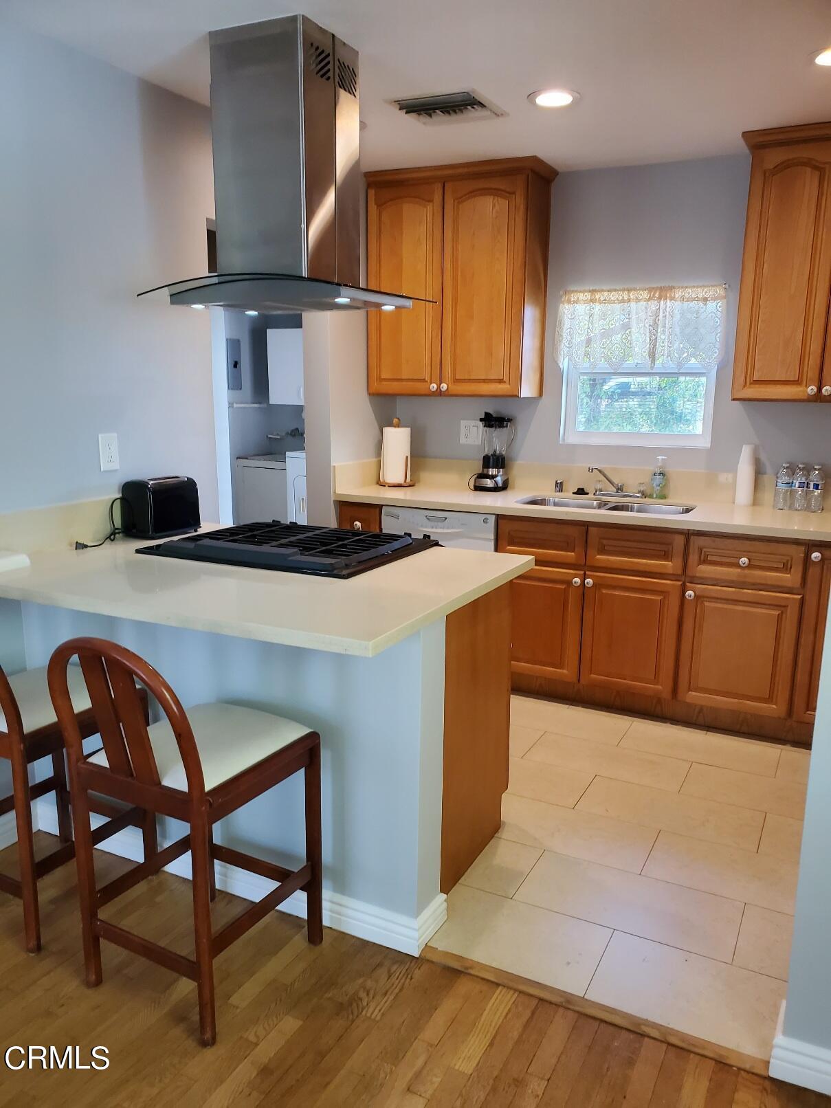 10651 Tinker Avenue Tujunga, CA 91042 - Photo 6 of 13 a kitchen with stainless steel appliances granite countertop a sink table and chairs