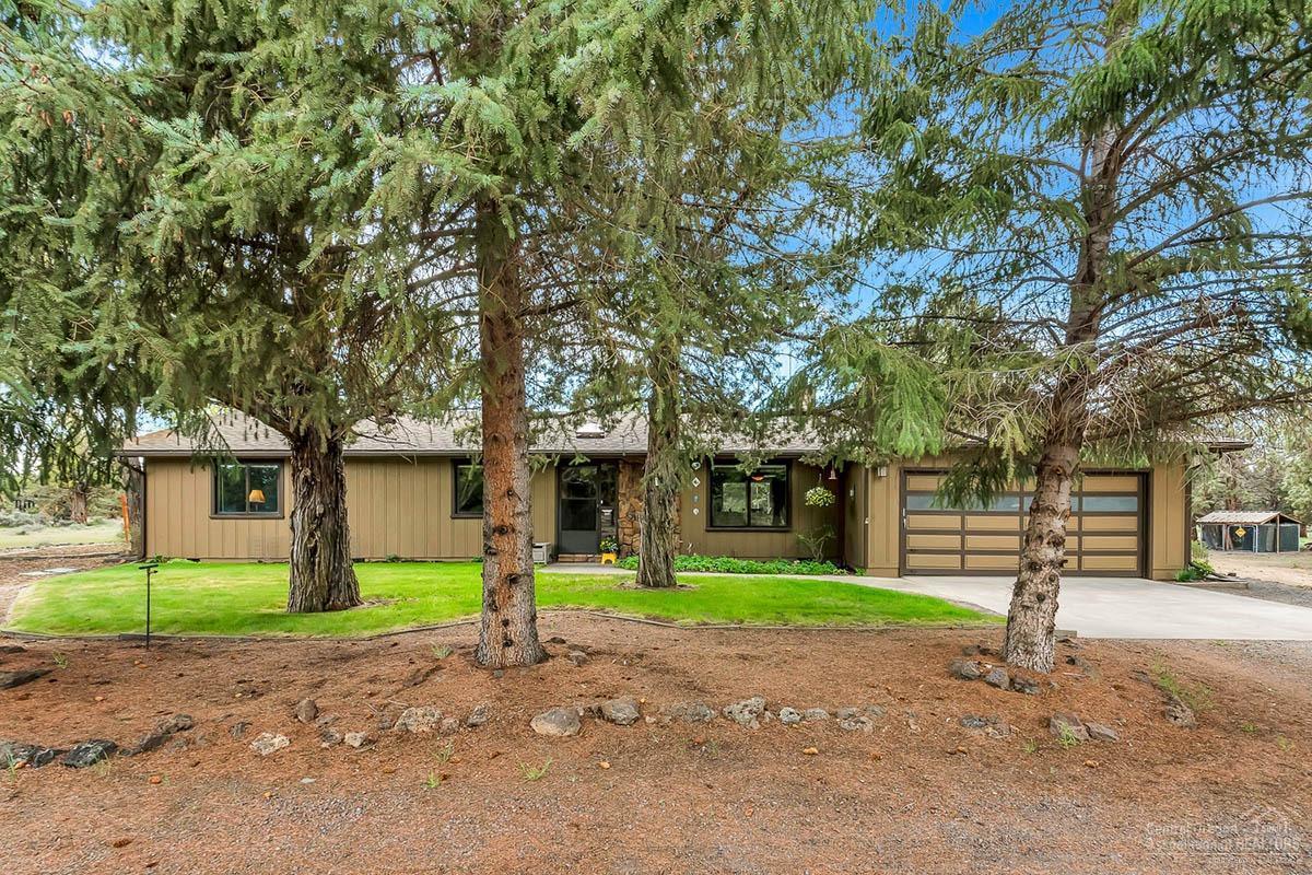 64729 Sylvan Loop Bend, OR 97701 - Photo 2 of 25 a front view of a house with a yard and palm trees