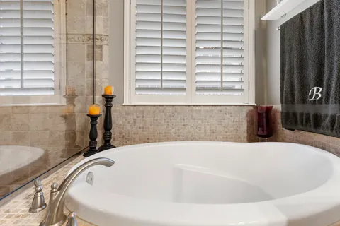 a bathroom with bathtub and window