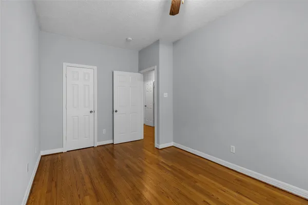 a view of an empty room with wooden floor