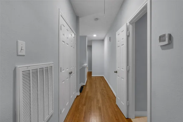 a view of a hallway with wooden floor and staircase