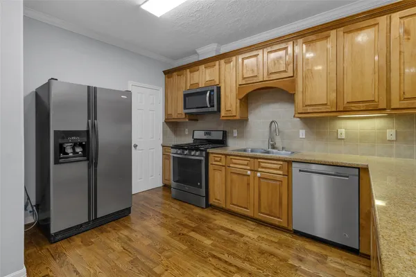 a kitchen with stainless steel appliances granite countertop a refrigerator sink and stove