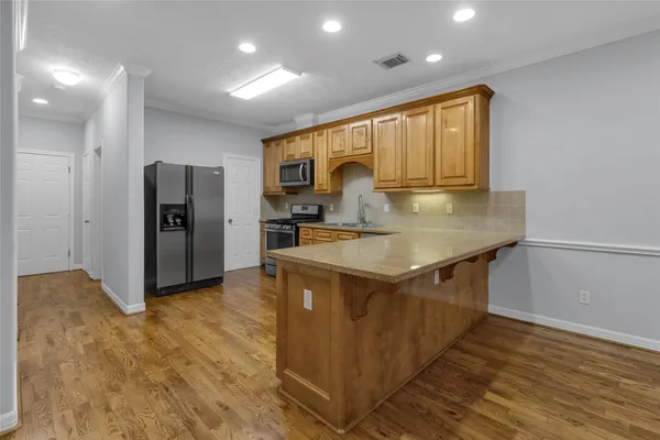 a kitchen with stainless steel appliances granite countertop a refrigerator a sink and a stove