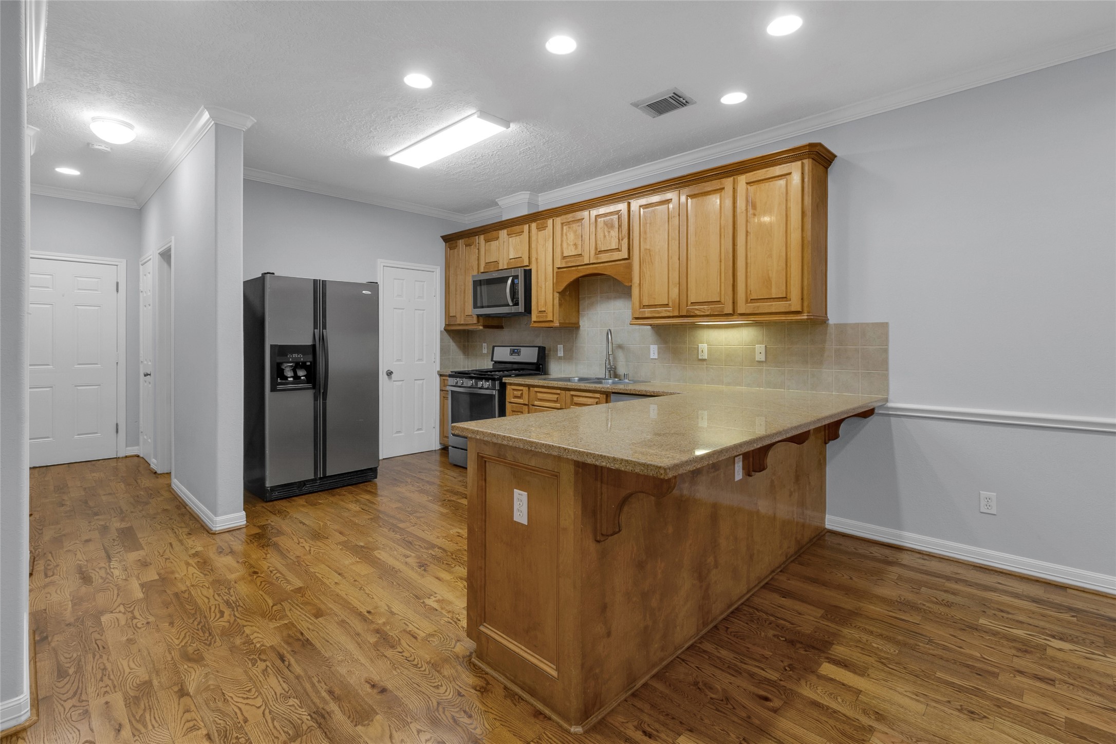 341 West 23rd Street Houston, TX 77008 - Photo 7 of 26 a kitchen with stainless steel appliances granite countertop a refrigerator a sink and a stove