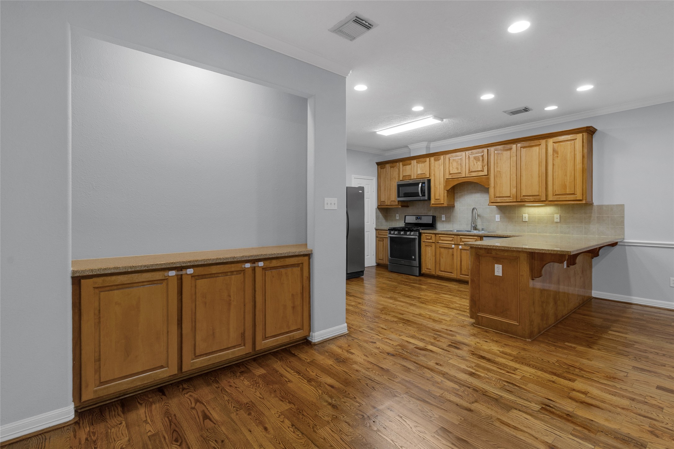 341 West 23rd Street Houston, TX 77008 - Photo 8 of 26 a kitchen with stainless steel appliances granite countertop a sink a stove and a wooden floors