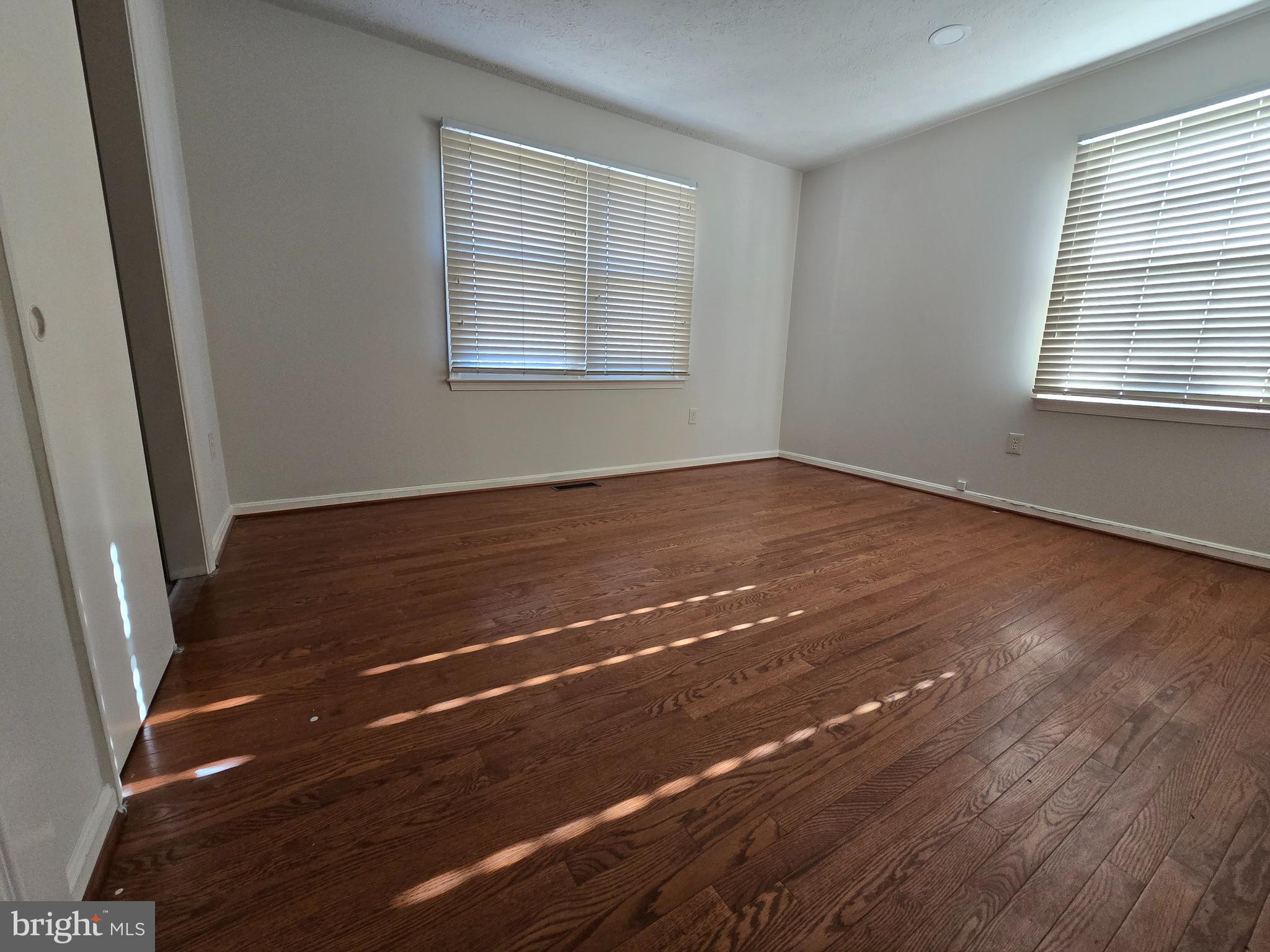 8907 Chad Way Clinton, MD 20735 - Photo 12 of 48 an empty room with wooden floor and windows