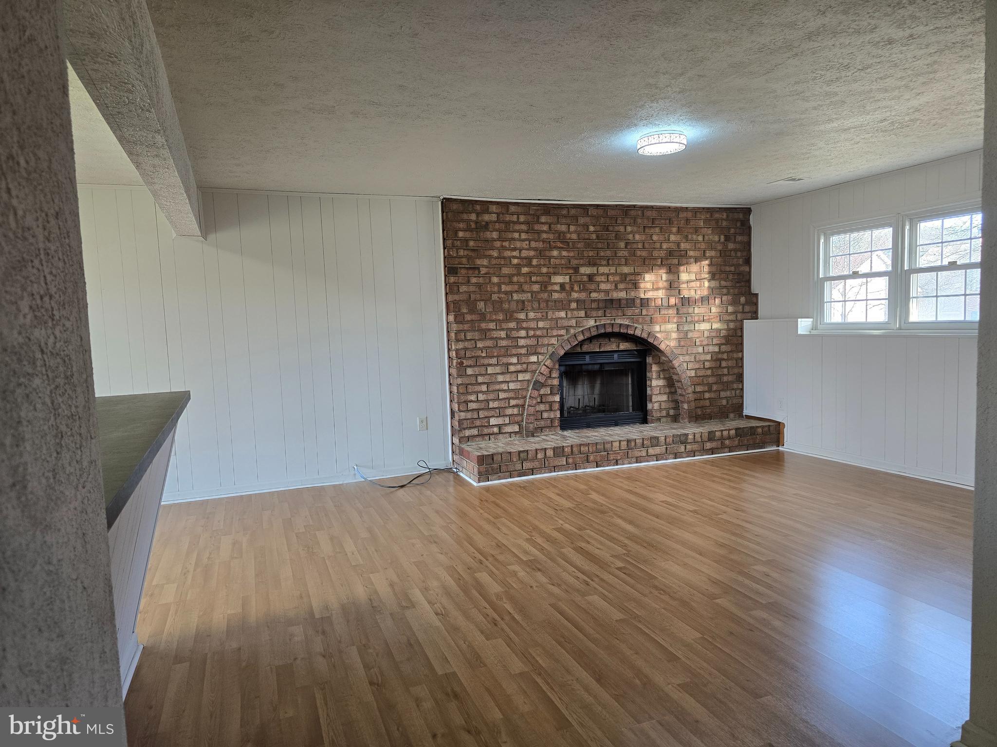8907 Chad Way Clinton, MD 20735 - Photo 24 of 48 an empty room with wooden floor fireplace and windows