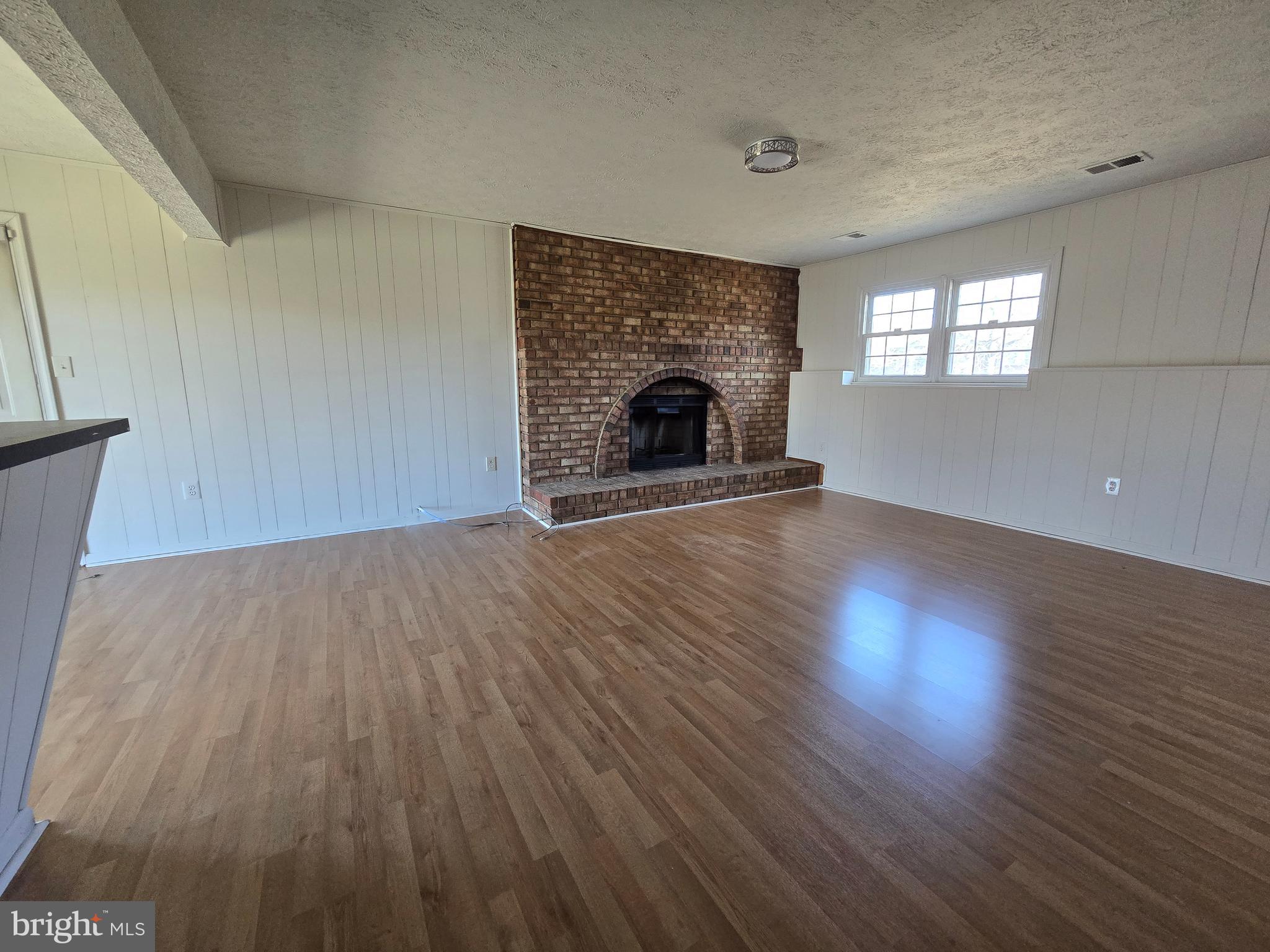 8907 Chad Way Clinton, MD 20735 - Photo 36 of 48 an empty room with wooden floor fireplace and windows