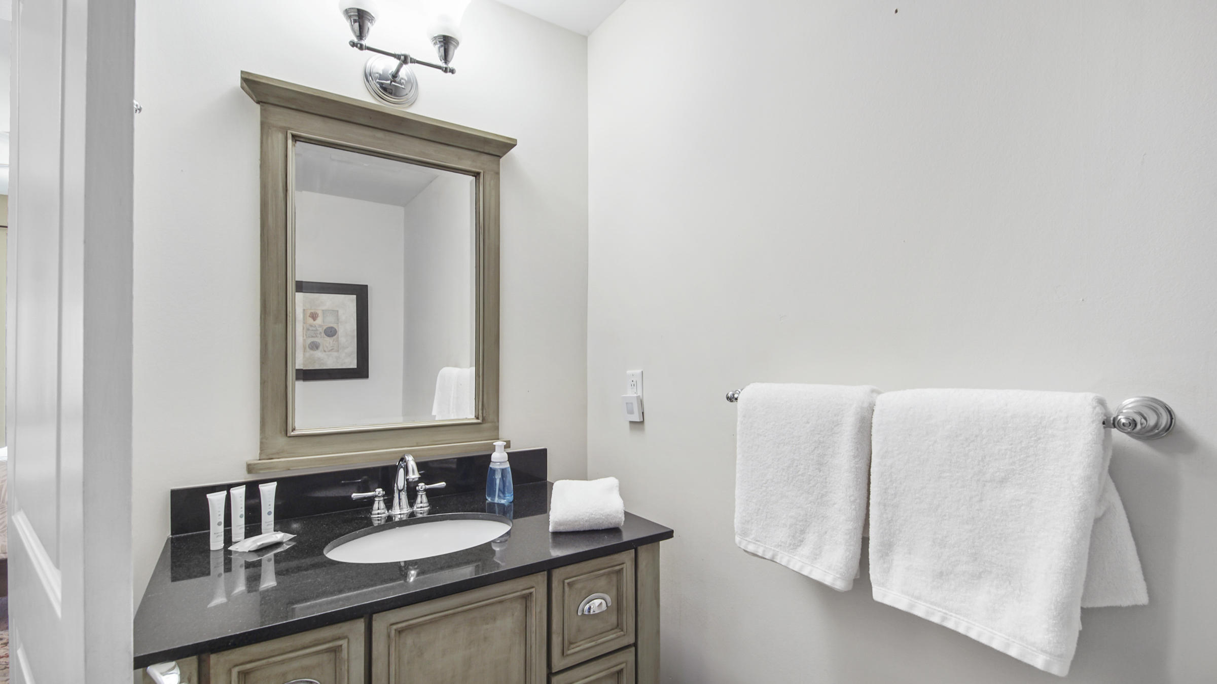 16701 Front Beach Road, Unit 1502 Panama City Beach, FL 32413 - Photo 16 of 33 a bathroom with a granite countertop sink and a mirror