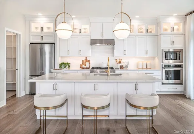 a kitchen with stainless steel appliances a dining table chairs and chandelier