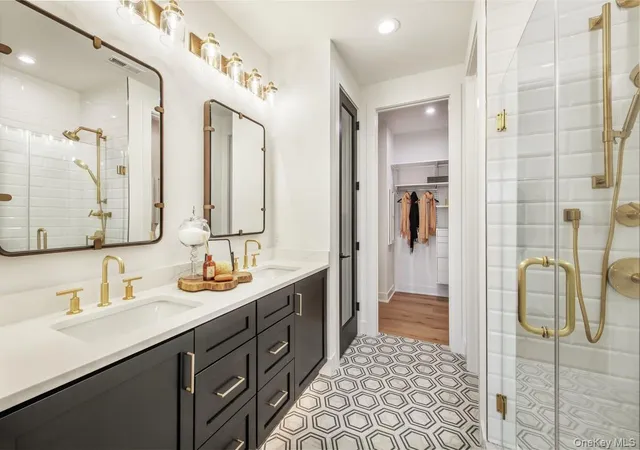 a bathroom with a double vanity sink mirror and shower