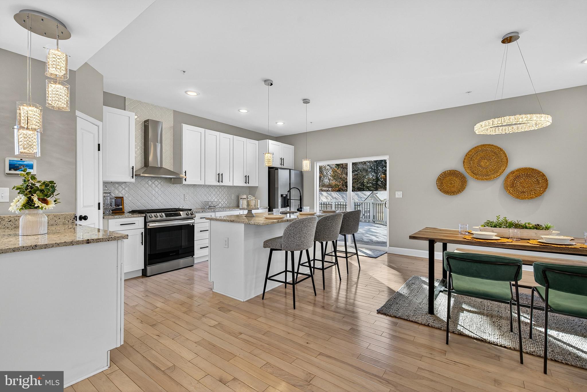 511 Patuxent Avenue Rosedale, MD 21237 - Photo 11 of 51 a kitchen with stainless steel appliances granite countertop a stove top oven a sink a dining table and chairs with wooden floor