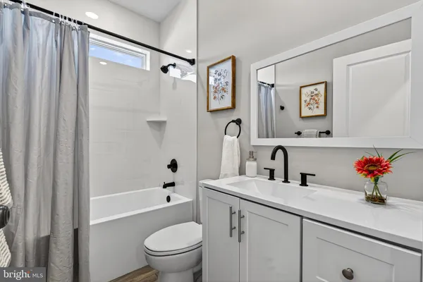 a bathroom with a sink mirror toilet and shower