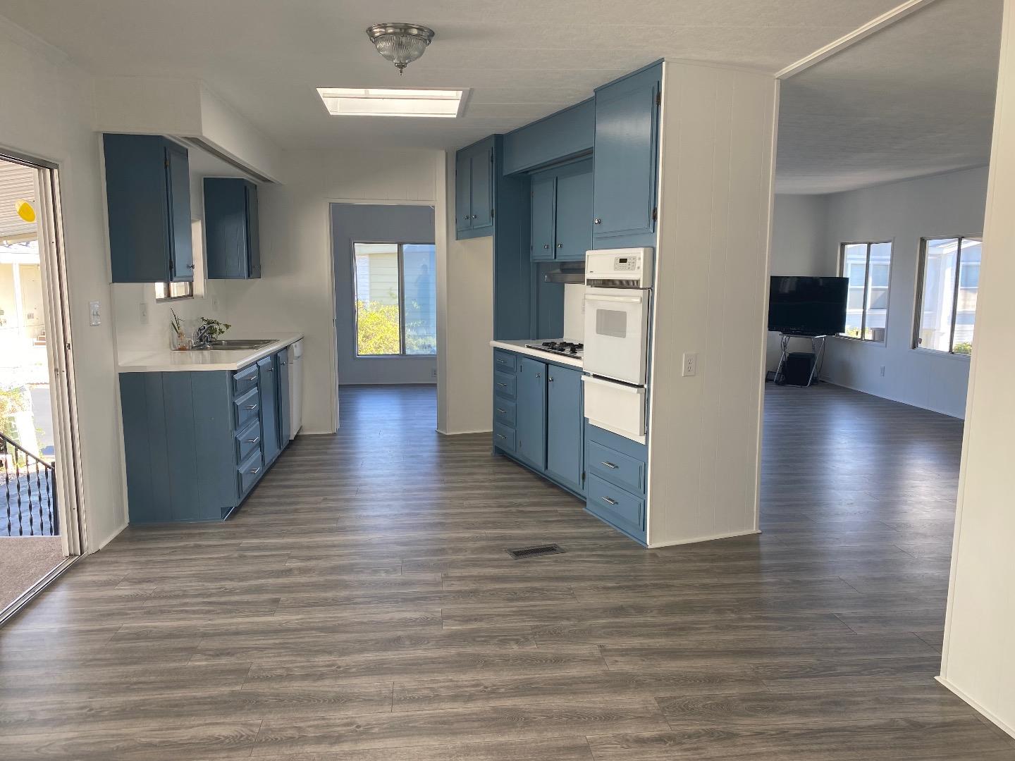 1220 Tasman Drive, Unit 159 Sunnyvale, CA 94089 - Photo 2 of 46 a large kitchen with a center island wooden floor and stainless steel appliances