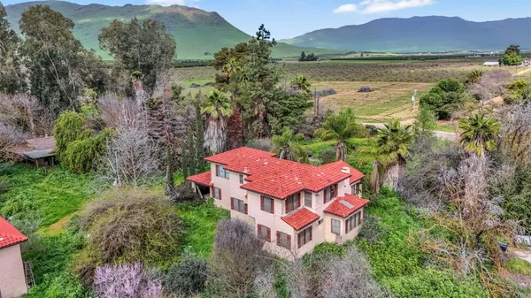 an aerial view of a house with garden space and lake view