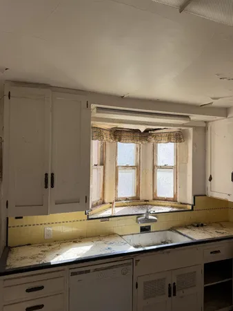 a bathroom with a granite countertop sink and a large mirror next to a window