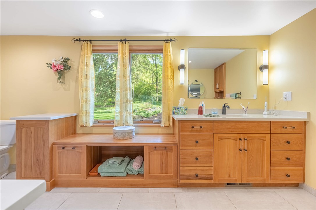 156 West Hadley Road Dayton, OH 45419 - Photo 27 of 71 Bright and airy, this bathroom offers a functional vanity, window bench, and serene outdoor views.