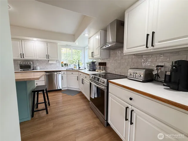 a kitchen with kitchen island a counter top space a refrigerator and a sink