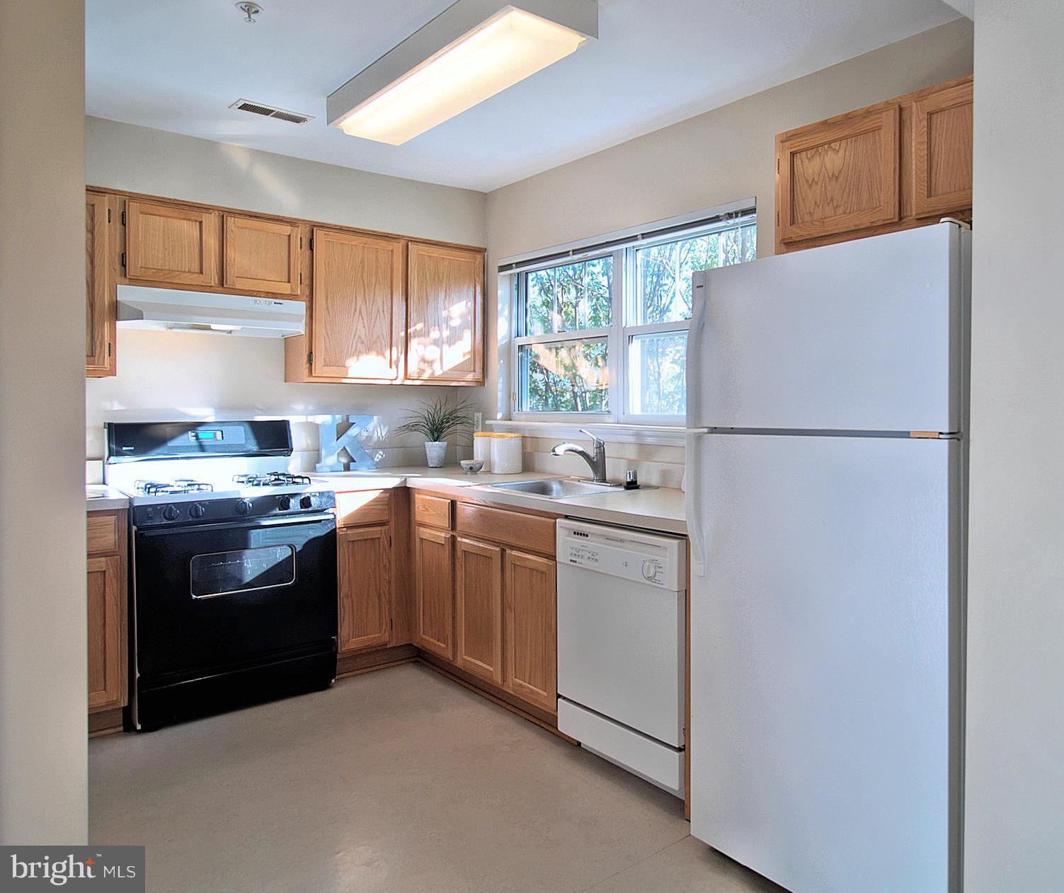 6827 4th Street Northwest, Unit 304 Washington, DC 20012 - Photo 9 of 23 a kitchen with a white cabinets and white appliances