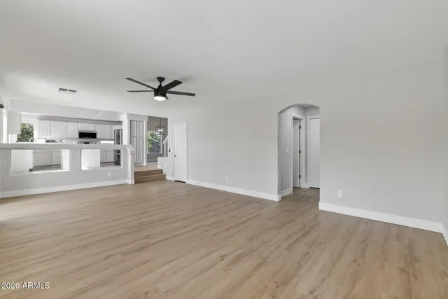a view of a livingroom with wooden floor and a ceiling fan