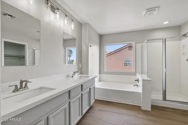 an empty room with a chandelier fan and windows