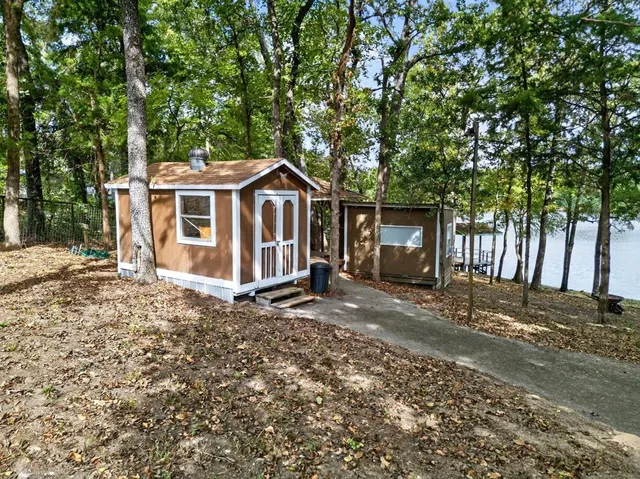 a view of a house with a yard and large tree