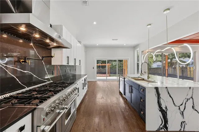 a kitchen with a stove and a wooden floor