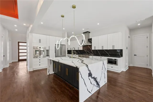 a kitchen with stainless steel appliances a refrigerator and a stove top oven