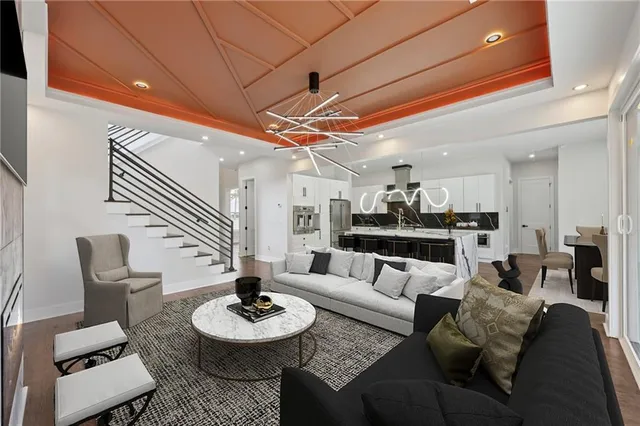 a kitchen with stainless steel appliances a stove top oven a sink dishwasher and a refrigerator with wooden floor